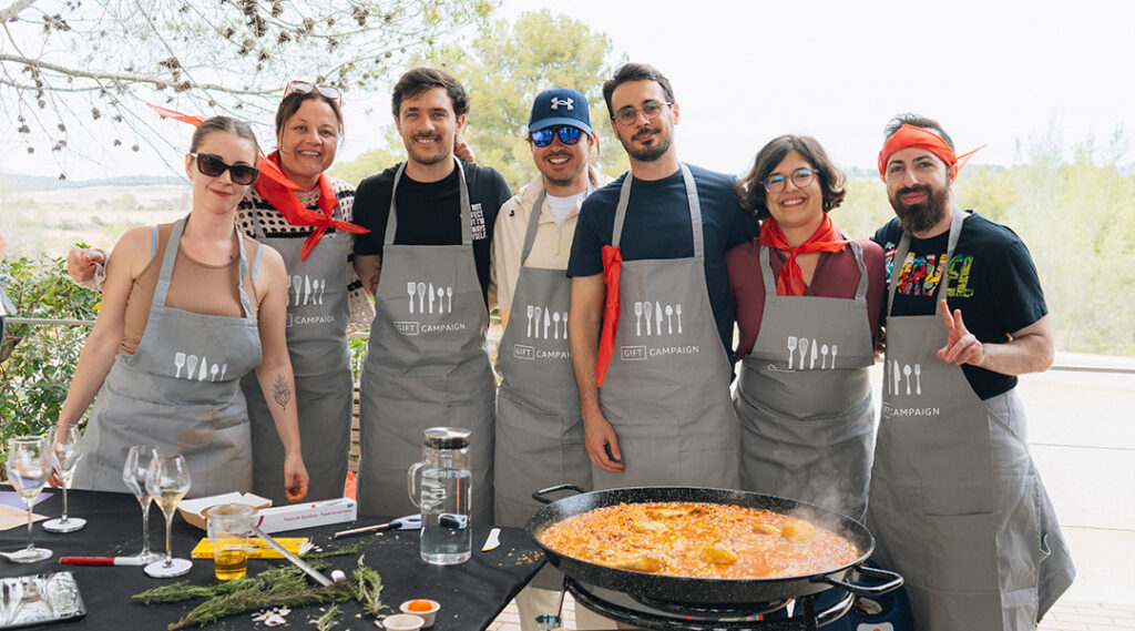 grupo de 7 colegas, cozinhando uma paella em atividades de team building